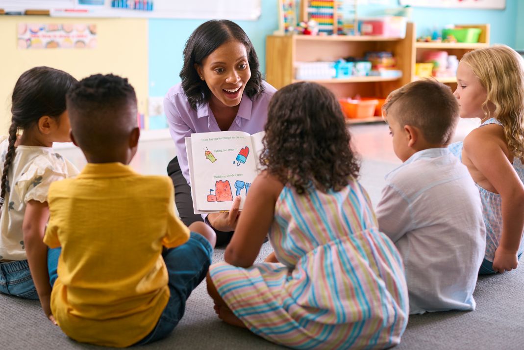 woman teaching five children in a speech delay class